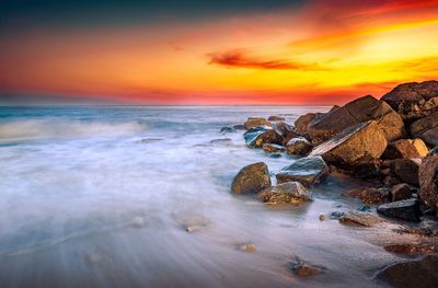 Scenic view of sea against romantic sky at sunset