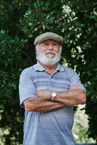 Portrait of a stylish older man wearing a beret on a green background