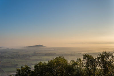 Scenic view of landscape against clear sky at sunset