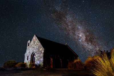 House on field against sky at night