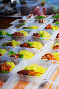 Typical malaysian daily food at street stall or bazaar called nasi ayam tomato packed in container .