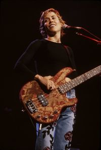 Young woman playing guitar against black background