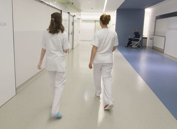 Rear view of people walking in corridor of building