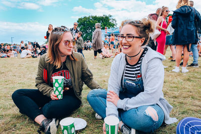 Portrait of friends sitting on field