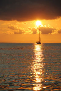 Sailboat in sea at sunset