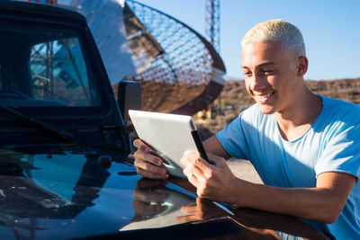 Smiling man using mobile phone while sitting in bus