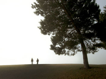 Silhouette people standing on field against sky