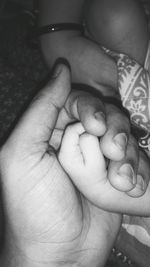 Close-up of father holding baby hand