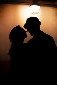 Silhouette couple against orange sky during sunset