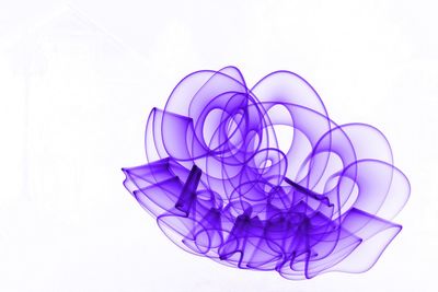 Close-up of multi colored glass on table against white background
