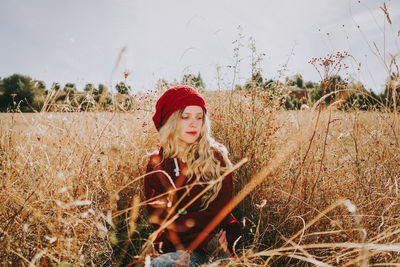 Portrait of young woman wearing hat on field