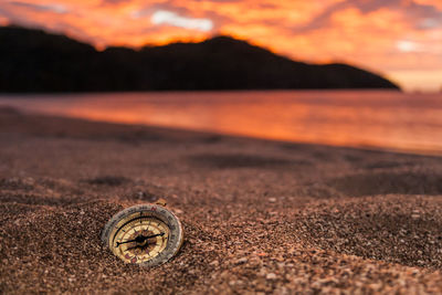 Surface level of beach against sky during sunset