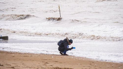 Mid adult man photographing at beach