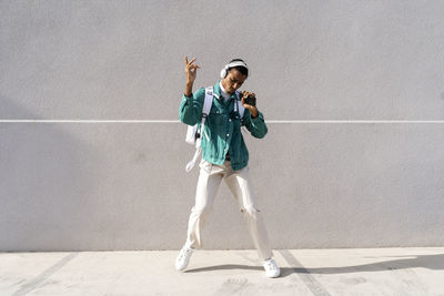 Full length of girl standing against wall