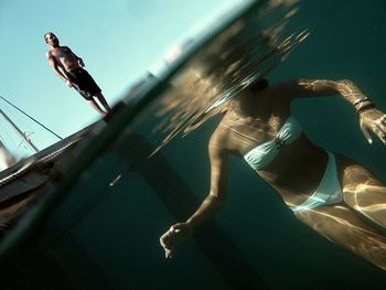 Midsection of young woman swimming in lake