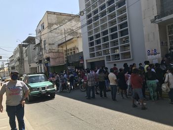 People on street against buildings in city