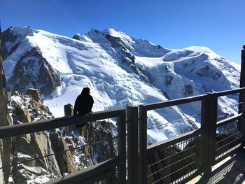 People on snowcapped mountain against sky