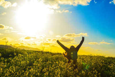 Woman with flowers on field against sky