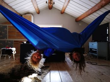 Portrait of girls playing on hammock at home