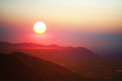 Scenic view of silhouette mountains against sky during sunset