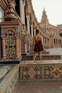 A young woman standing in front of a historic building - plaza de espana. spanish square