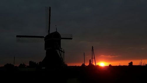 Silhouette of windmill against sky at sunset