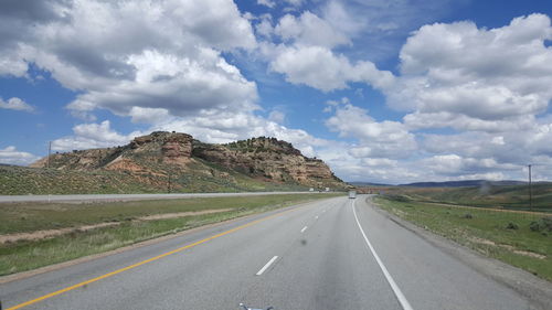 Road by landscape against sky