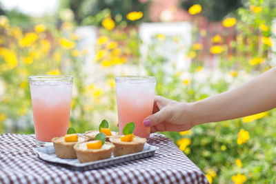 Cropped hand of woman having food and drink at table