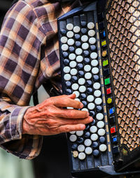 Midsection of man playing accordion