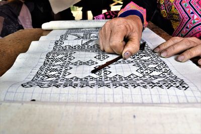 Cropped image of woman making artwork on fabric