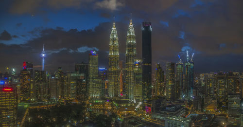 Illuminated cityscape against sky at night