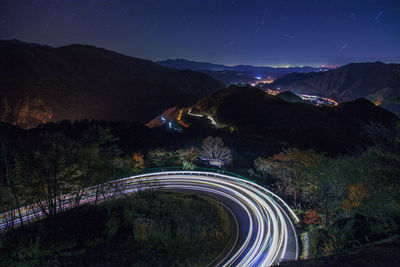 Light trails on road against sky at night