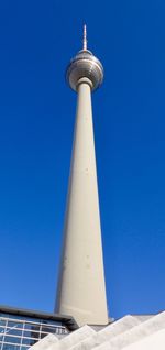 Low angle view of communications tower against blue sky