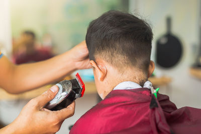 Cropped image of barber cutting boy hair