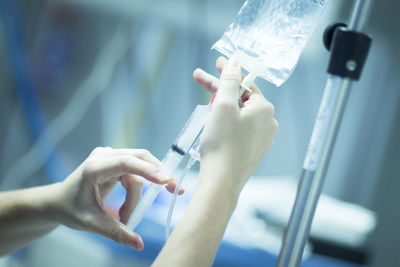 Cropped image of doctor filling medicine in syringe