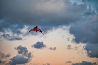 Low angle view of kite flying against sky during sunset