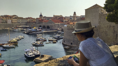 Rear view of woman on boat against buildings