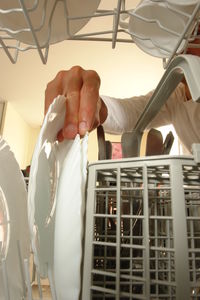 Midsection of man arranging plates in rack