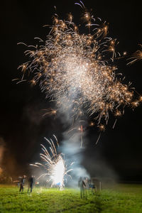 Firework display on field at night