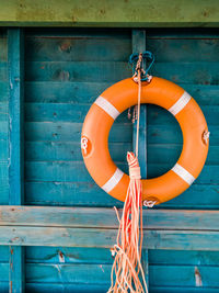 Close-up of life belt and rope hanging against wall