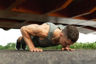 Low section of man exercising on road