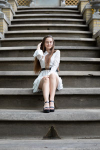 Low angle view of woman sitting on staircase