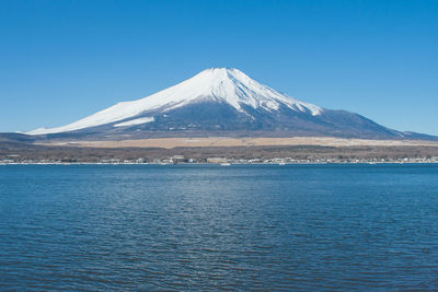 Scenic view of snowcapped mountains against clear blue sky