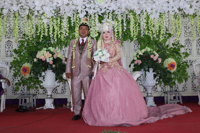 Couple standing by flowers