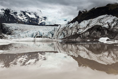 Scenic view of frozen lake against mountain range