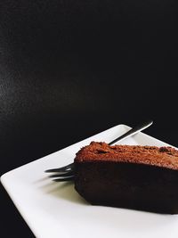 View of chocolate cake in plate against black background