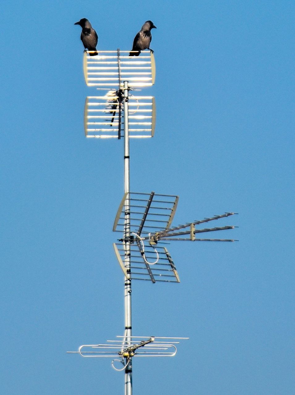 Low angle view of antenna against clear blue sky