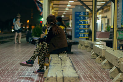 Rear view of woman sitting on floor