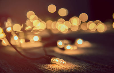 Close-up of illuminated string lights on wooden table