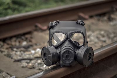 Close-up of gas mask on railroad track